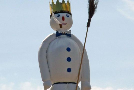 Schneeman mit Krone und Pfeife im Mund, der Böögg.