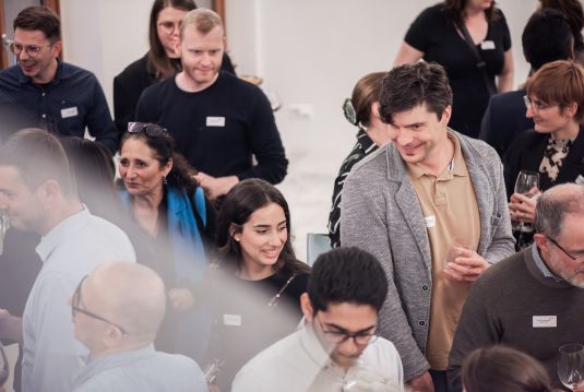 eilnehmende im Gespräch an einem Coopers Networking