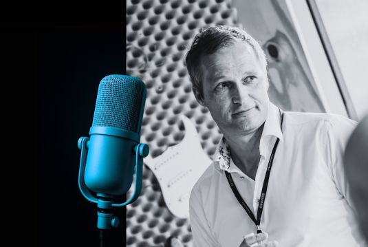 Oliver Kahle in front of a microphone, black-and-white photo