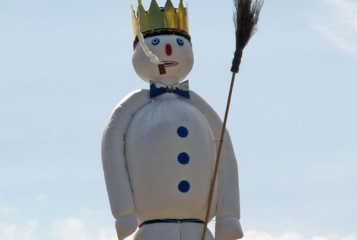 Schneeman mit Krone und Pfeife im Mund, der Böögg.