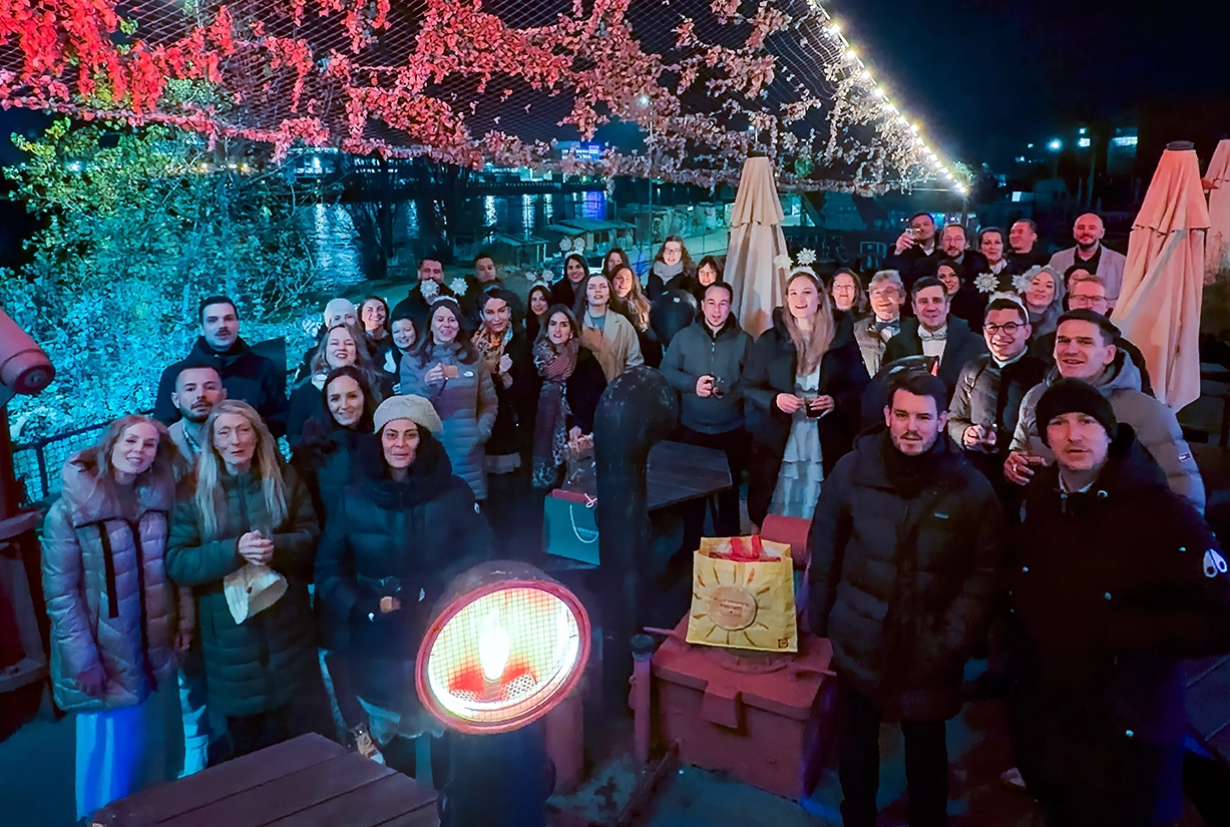 Group of people in winter jackets on the ship Gannet with evening atmosphere and many lights